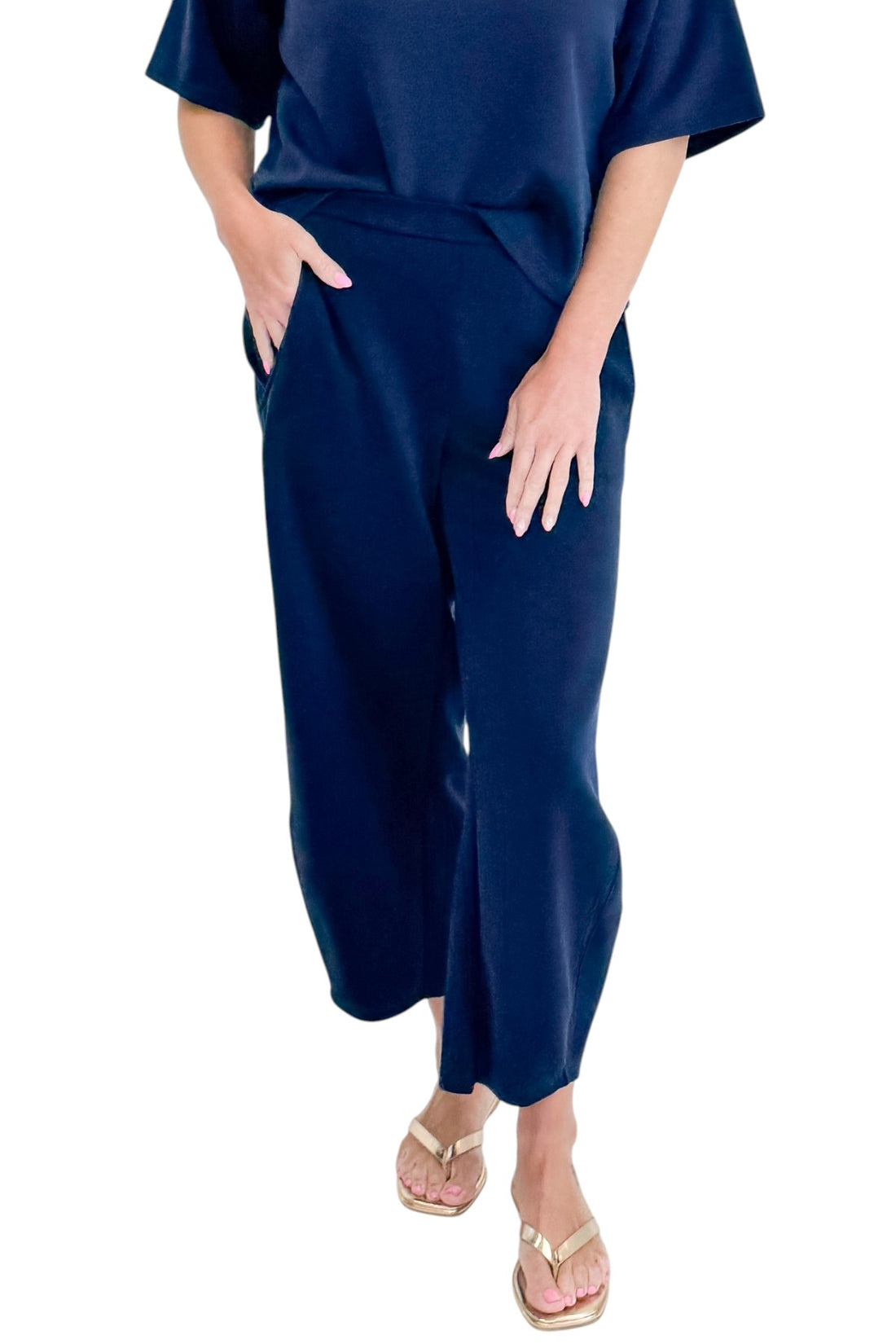 Front detail view of woman wearing Swagger Boutique’s Navy Barrel Lounge Pants with Navy Round Neck Short Sleeve Top against white studio background.