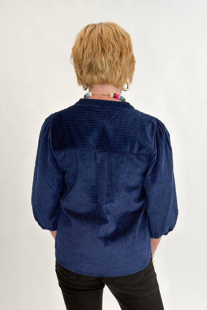 Back view of woman wearing Swagger Boutique’s Navy Corduroy Half Sleeve Top with jeans against white studio background.