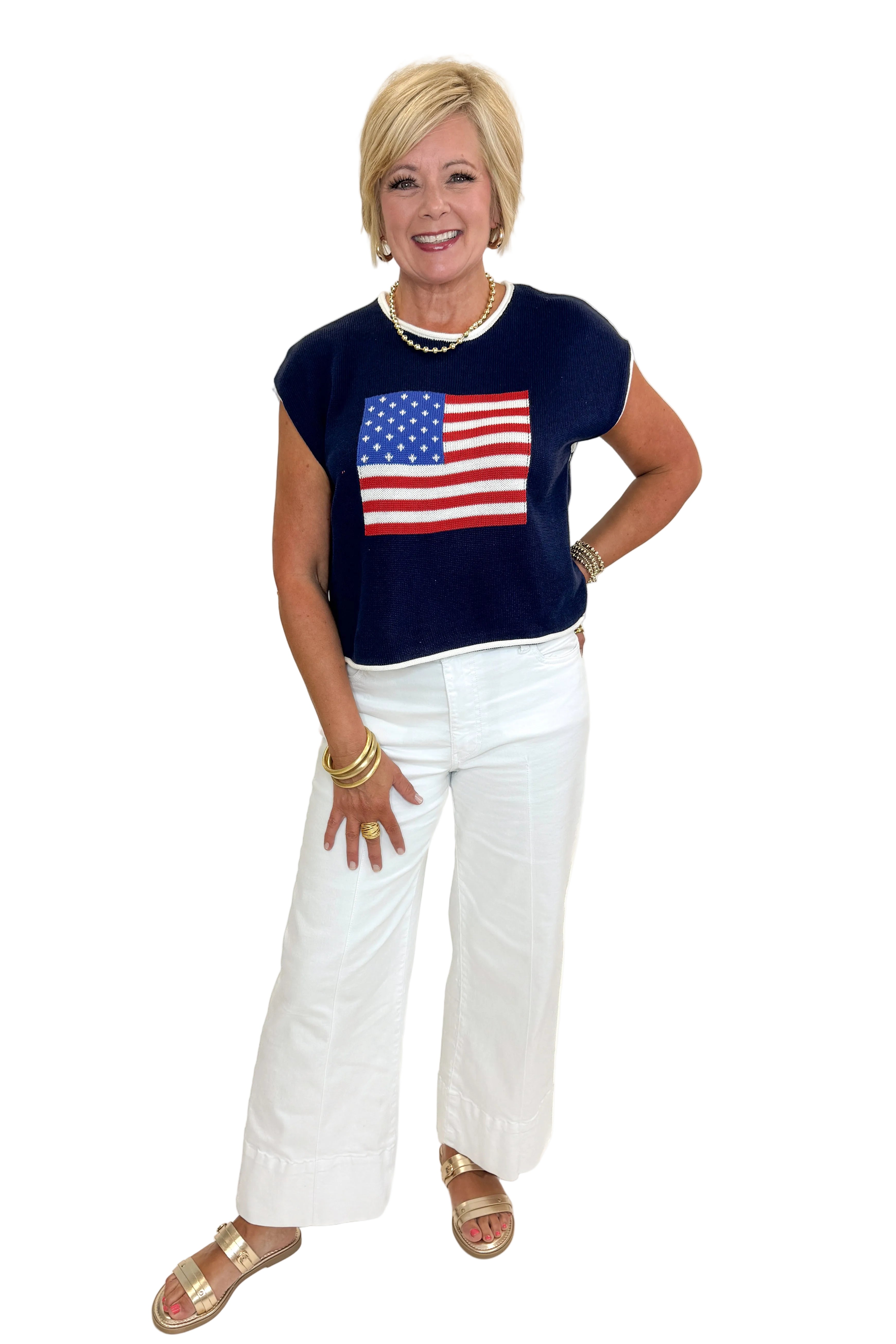 Front view of woman wearing Swagger Boutique’s Right On Cue Navy Flag Short Sleeve Sweater with jeans against white studio background.