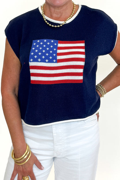 Front detail view of woman wearing Swagger Boutique’s Right On Cue Navy Flag Short Sleeve Sweater with jeans against white studio background.
