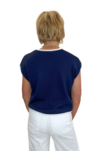 Back view of woman wearing Swagger Boutique’s Right On Cue Navy Flag Short Sleeve Sweater with jeans against white studio background.