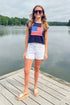 Front view of woman wearing Swagger Boutique’s Right On Cue Navy Flag Short Sleeve Sweater with jean shorts at the lake.
