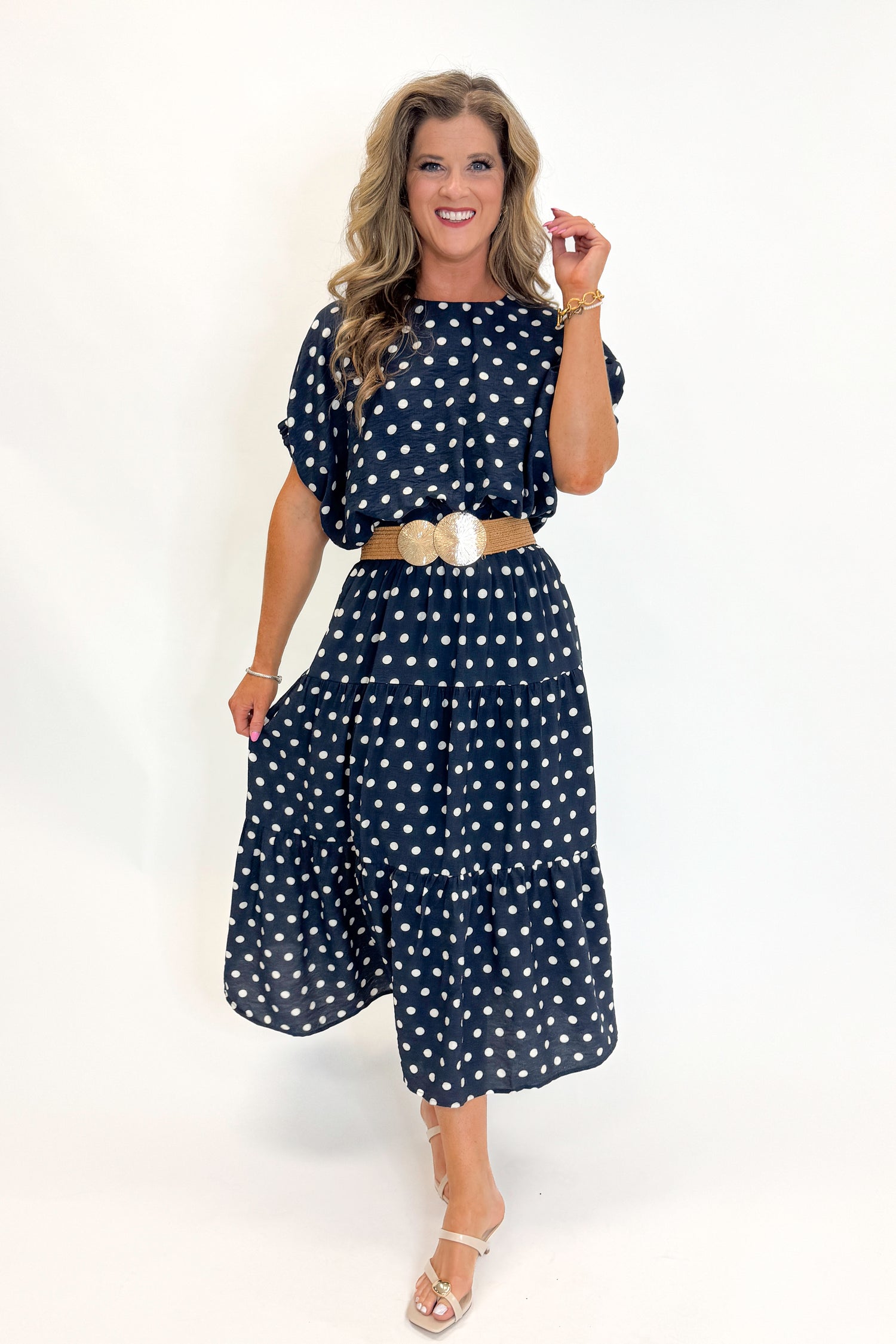 Front view of woman wearing Swagger Boutique’s Navy Polka Dot Bubble Hem Top by Entro with matching Navy Polka Dot Tiered Skirt by Entro against white studio background.