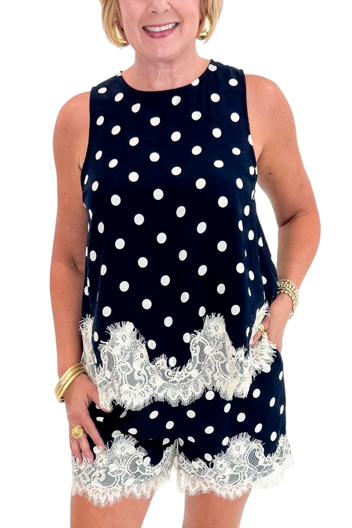 Front detail view of woman wearing Swagger Boutique’s Navy Polka Dot Lace Trim Shorts by Entro with matching tank against white studio background.