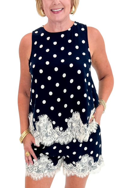 Front detail view of woman wearing Swagger Boutique’s Navy Polka Dot Lace Trim Shorts by Entro with matching tank against white studio background.