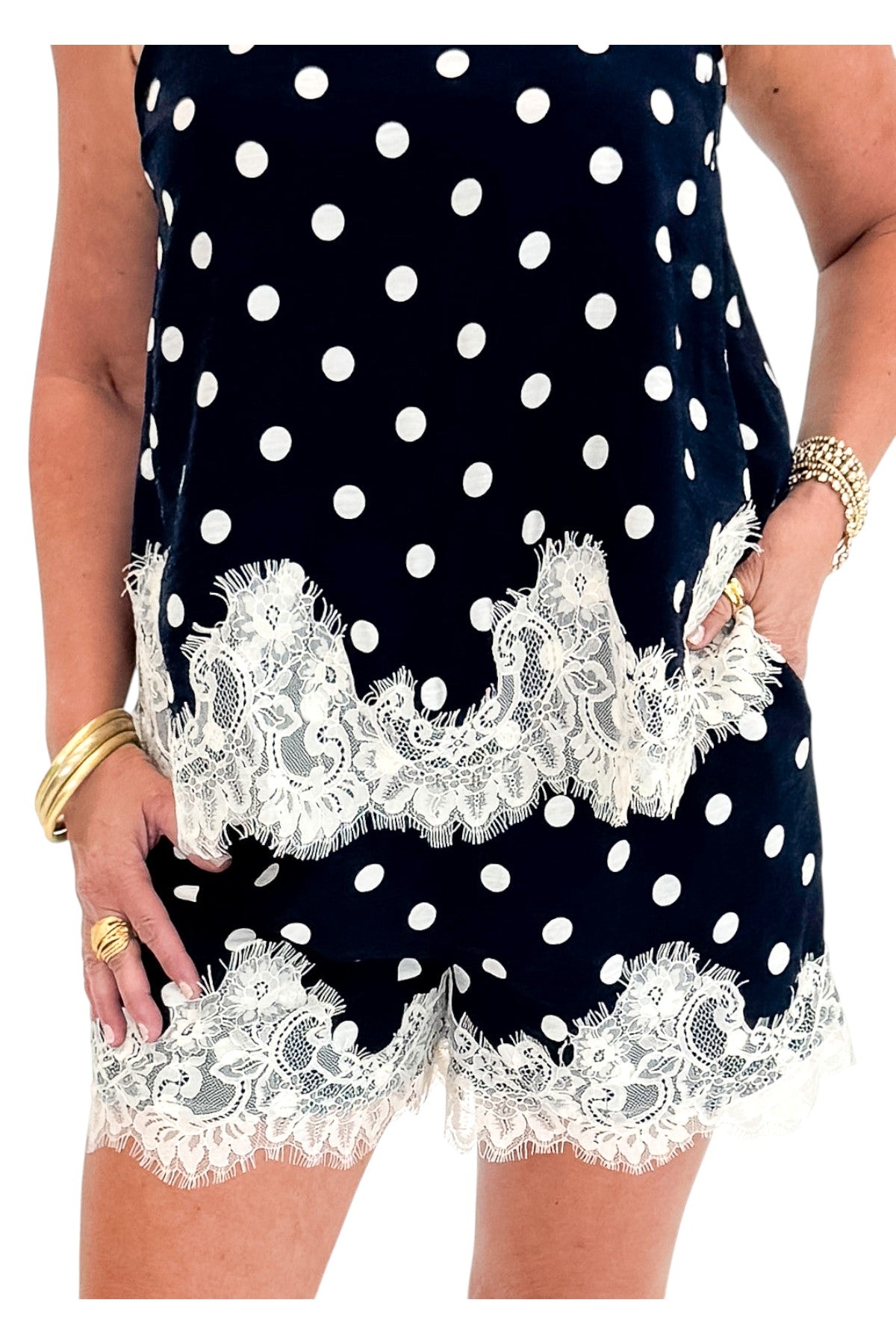 Front detail view of woman wearing Swagger Boutique’s Navy Polka Dot Lace Trim Shorts by Entro with matching tank against white studio background.