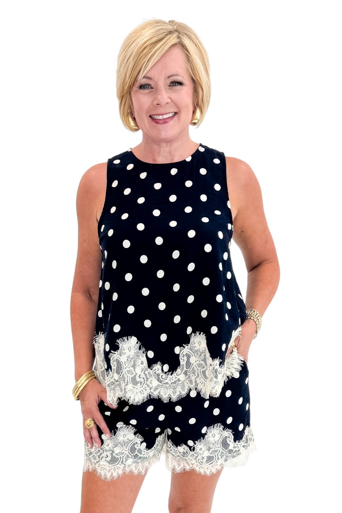 Front view of woman wearing Swagger Boutique’s Navy Polka Dot Lace Trim Shorts by Entro with matching tank against white studio background.
