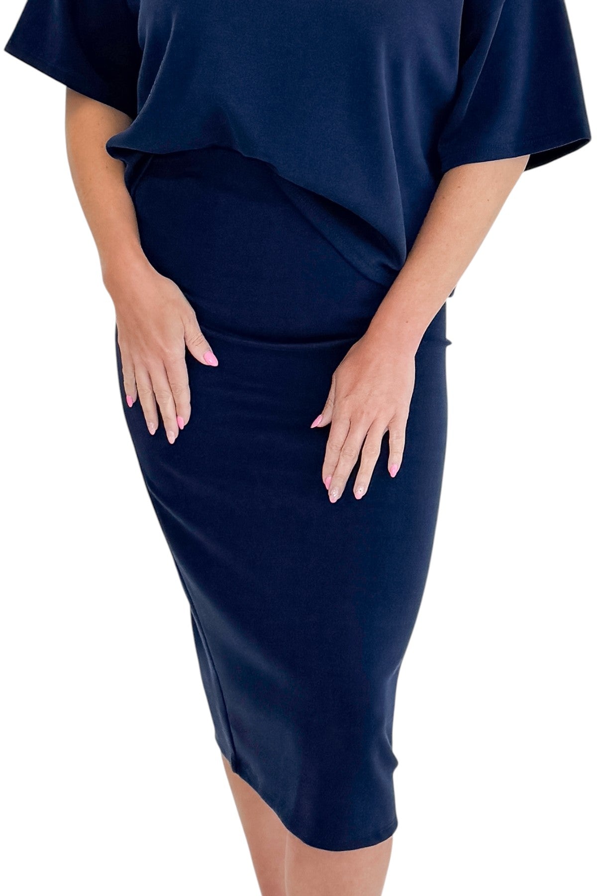 Front detail view of woman wearing Swagger Boutique’s Navy Midi Skirt with Navy Round Neck Short Sleeve Top against white studio background.