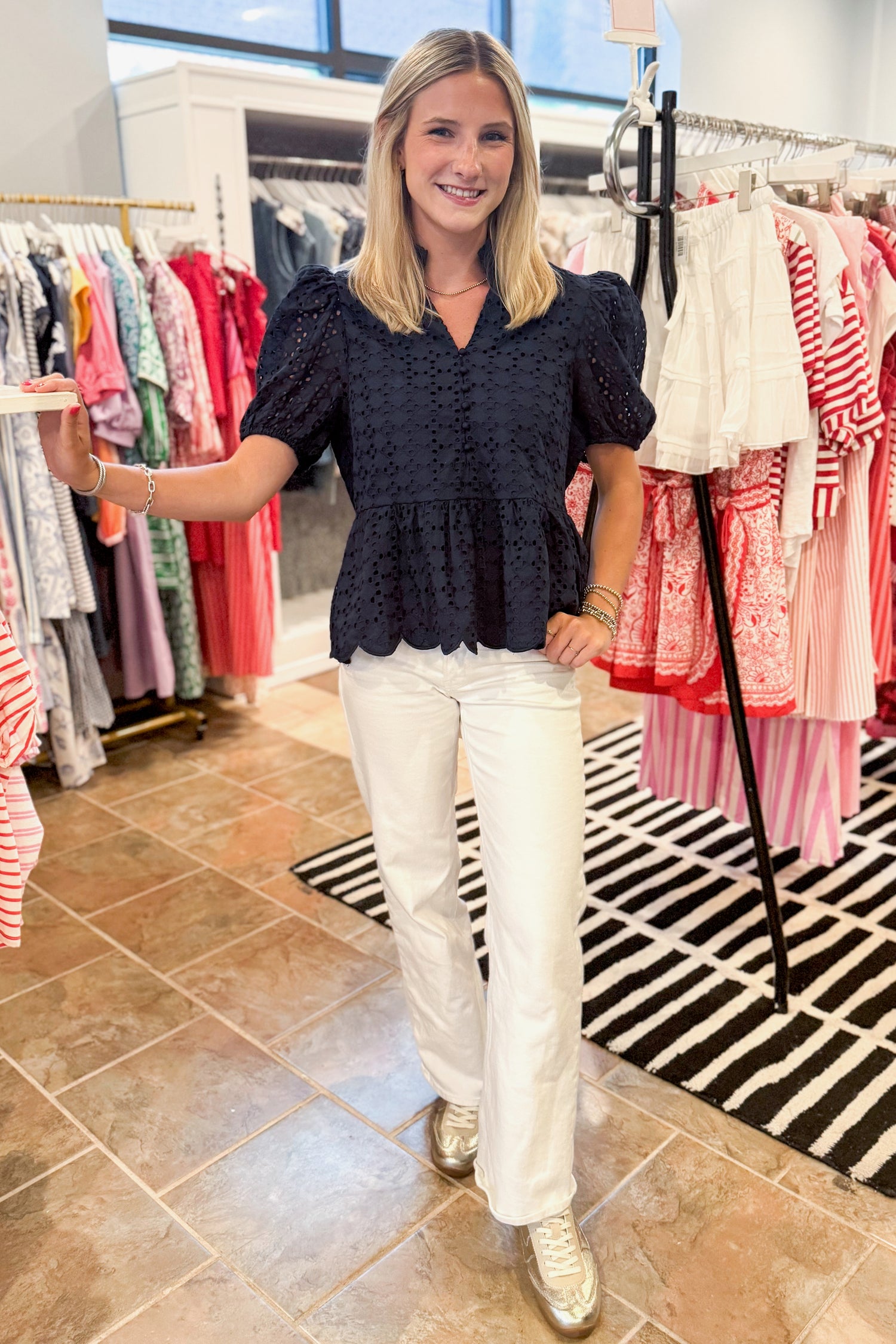 Front view of woman wearing Navy Short Sleeve Peplum Eyelet Top at swagger boutique. 