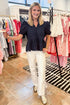 Front view of woman wearing Navy Short Sleeve Peplum Eyelet Top at swagger boutique. 