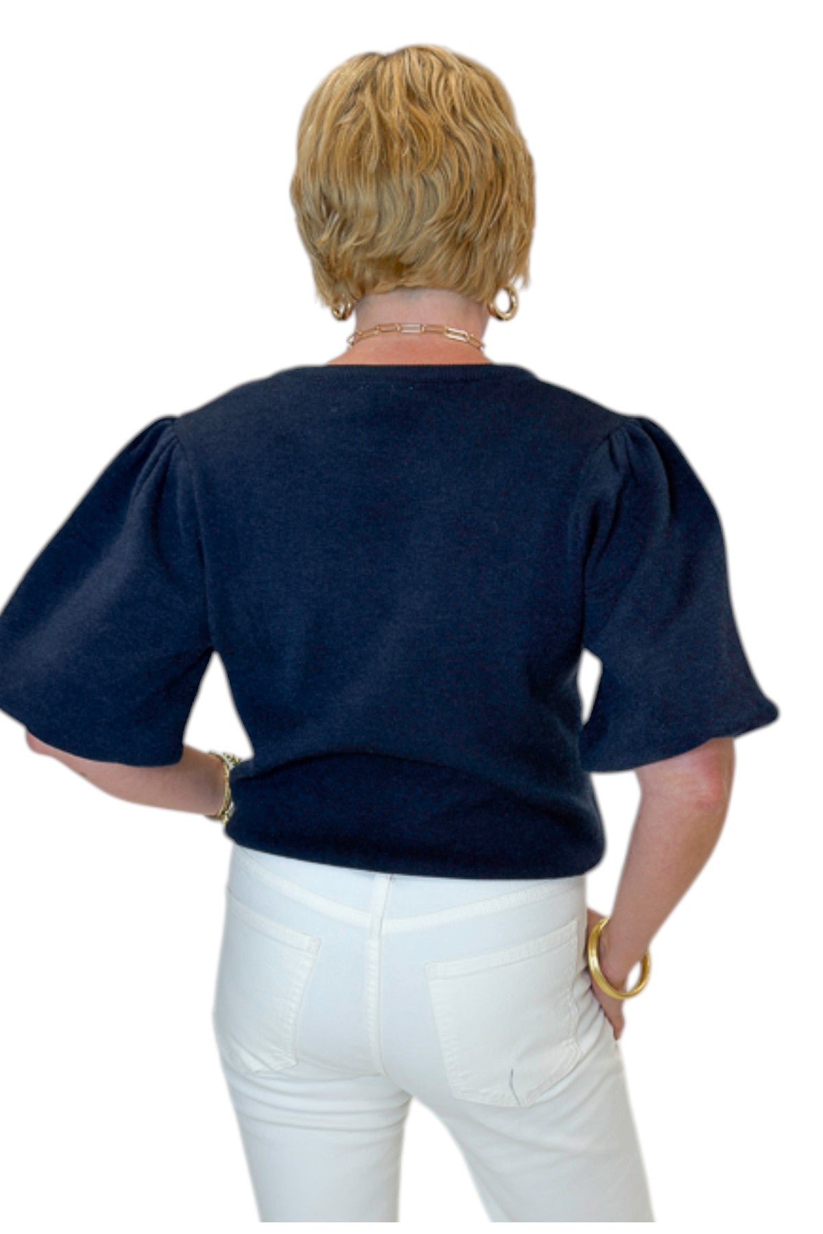 Back view of woman wearing Swagger Boutique’s Navy Short Sleeve Sweater with jeans against white studio background.