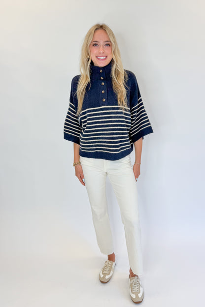 Front view of woman wearing Swagger Boutique’s Navy Striped 3/4 Sleeve Sweater by Entro with jeans against white studio background.