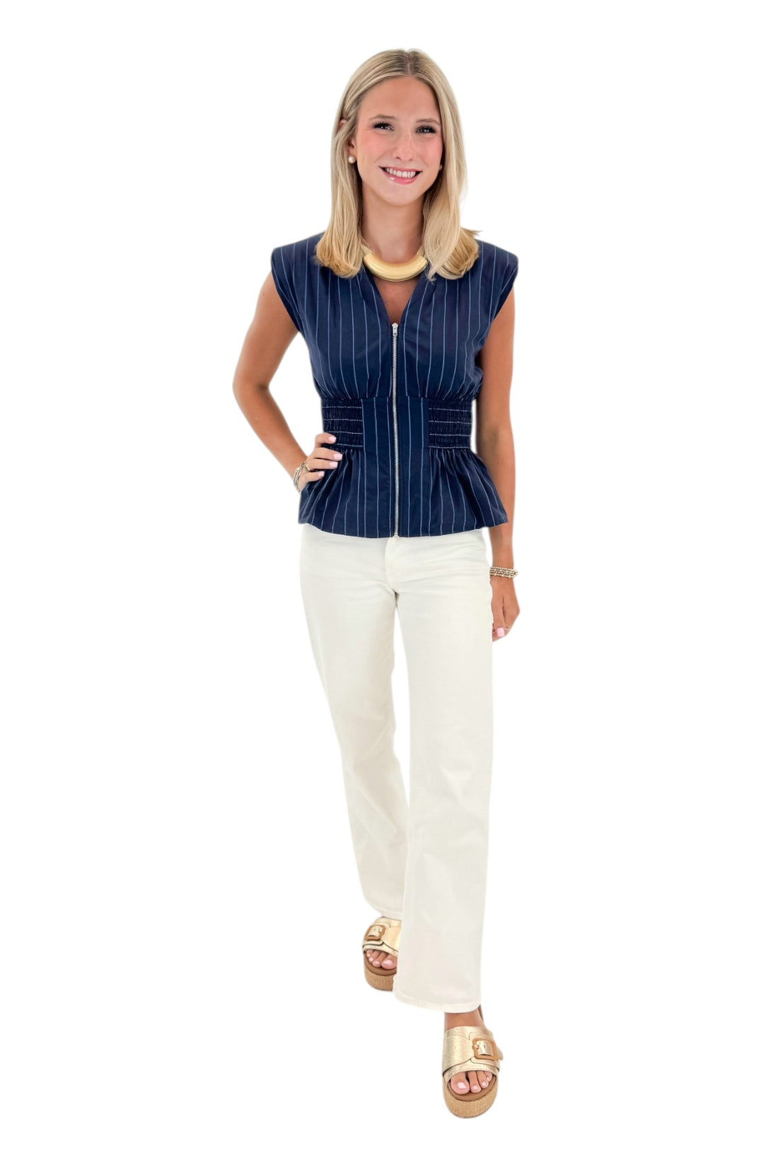 Front view of woman wearing Swagger Boutique’s Navy Striped Peplum Tank with jeans against white studio background.