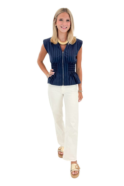 Front view of woman wearing Swagger Boutique’s Navy Striped Peplum Tank with jeans against white studio background.