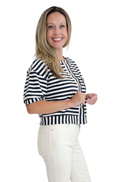 Side view of woman wearing Swagger Boutique’s Navy Striped Short Sleeve Button Up Top with jeans against white studio background.