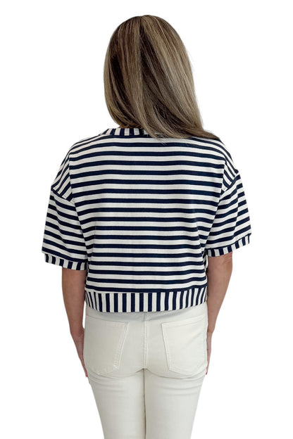 Back view of woman wearing Swagger Boutique’s Navy Striped Short Sleeve Button Up Top with jeans against white studio background.
