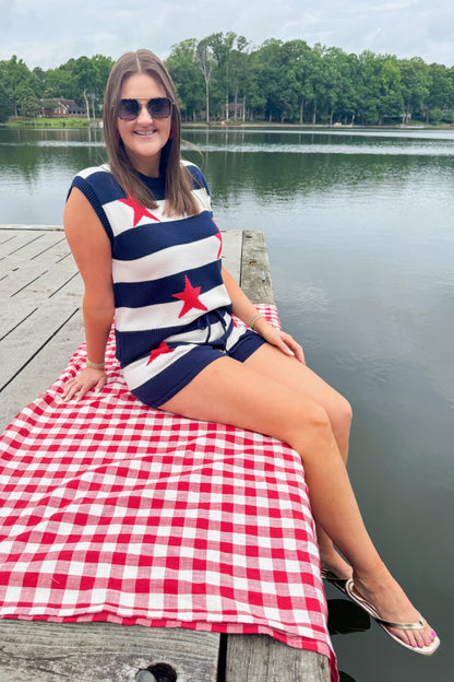 Front view of woman wearing Swagger Boutique’s Navy Striped Star Print Sleeveless Sweater with matching shorts outside at the lake.