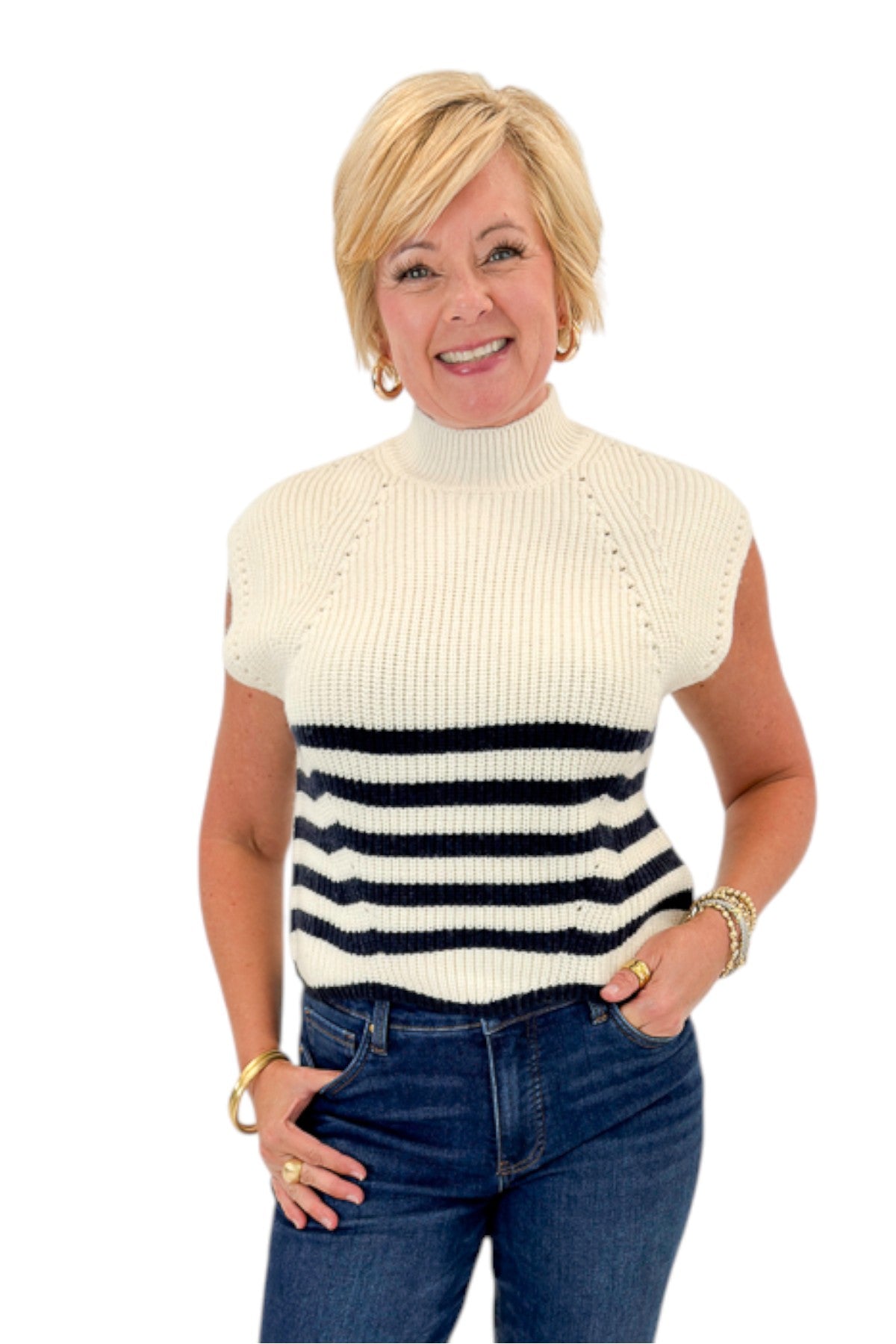 Front view of woman wearing Swagger Boutique’s Navy Striped Turtleneck Sleeveless Sweater with jeans against white studio background.