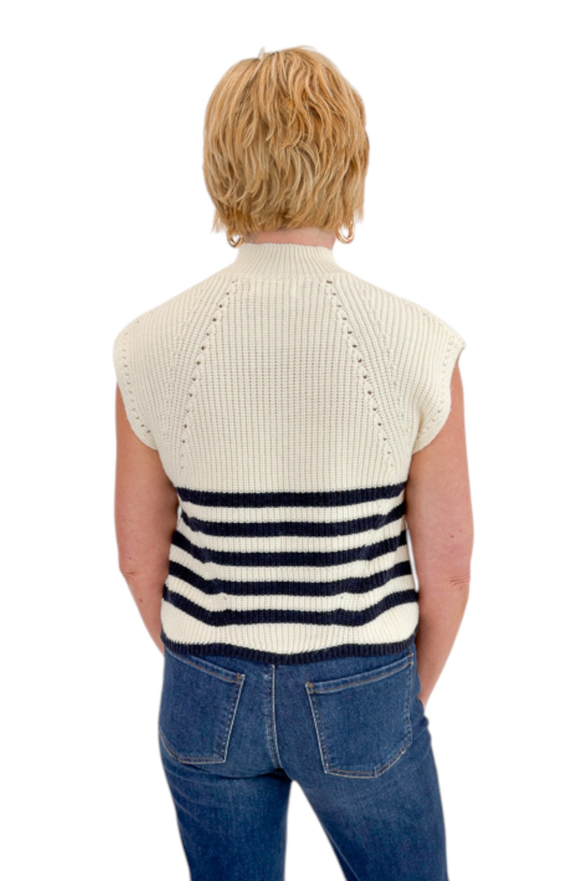 Back view of woman wearing Swagger Boutique’s Navy Striped Turtleneck Sleeveless Sweater with jeans against white studio background.