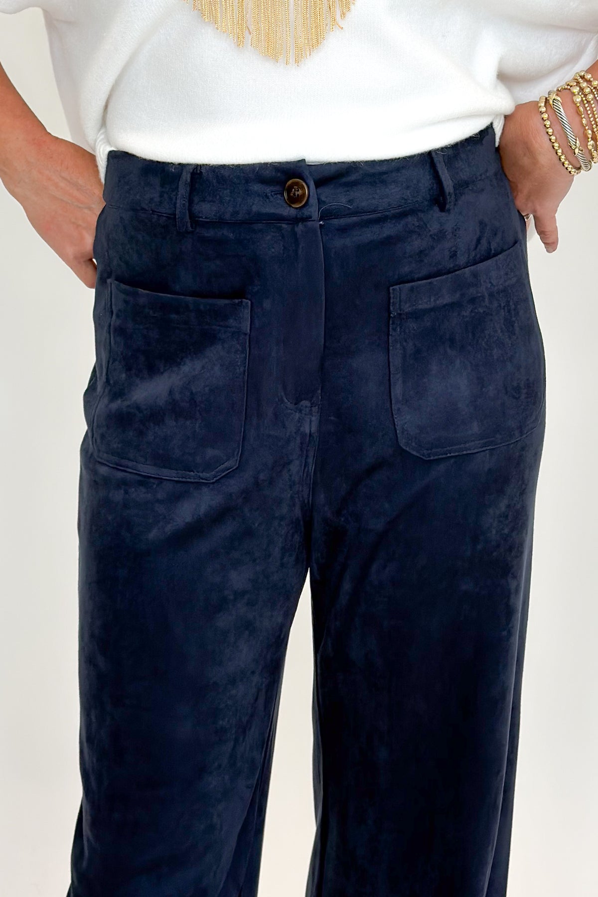 Front detail view of woman wearing Swagger Boutique’s Navy Suede Wide Leg Pants with sweater against white studio background.
