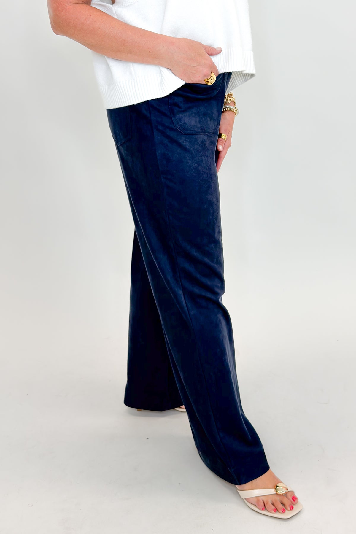 Side view of woman wearing Swagger Boutique’s Navy Suede Wide Leg Pants with sweater against white studio background.