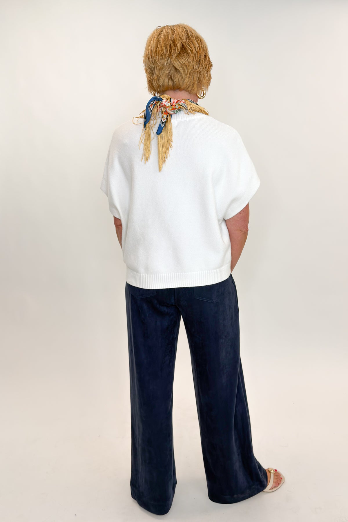 Back view of woman wearing Swagger Boutique’s Navy Suede Wide Leg Pants with sweater against white studio background.