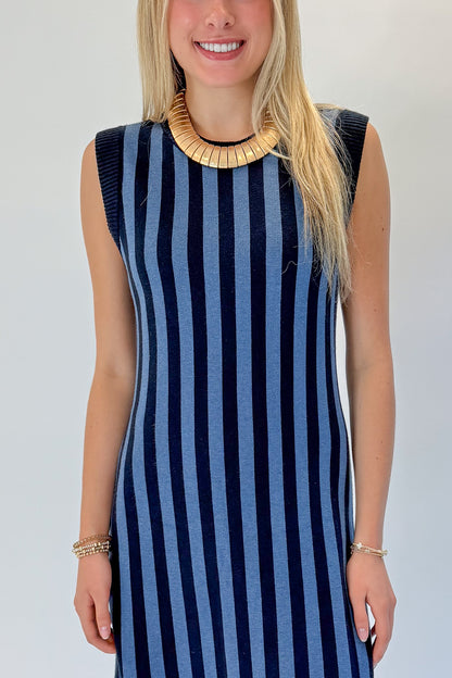 Front detail view of woman wearing Swagger Boutique’s Navy &amp; Blue Striped Midi Dress with heels against white studio background.