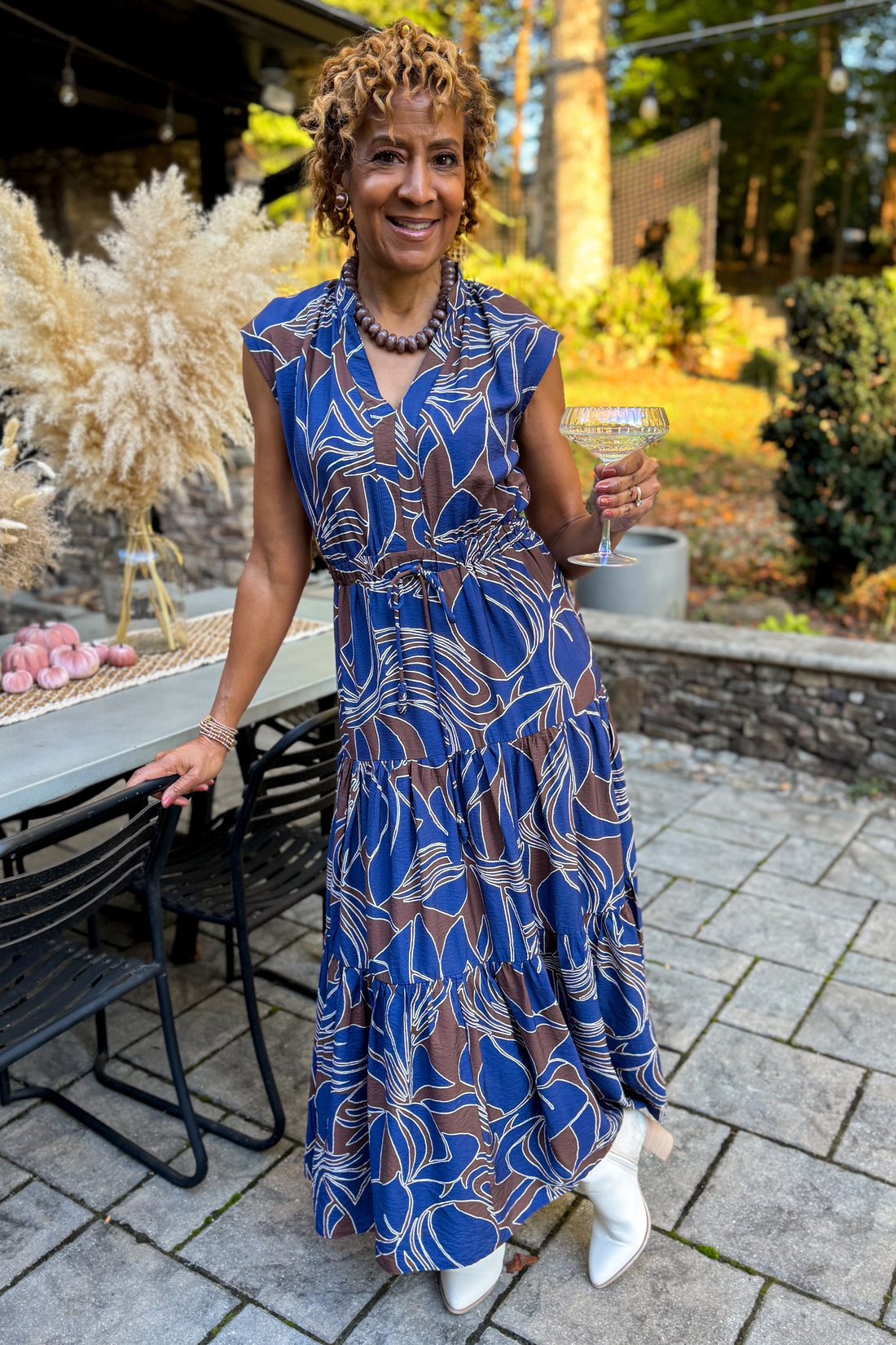 Front view of woman wearing Swagger Boutique’s Navy &amp; Brown Abstract Print Maxi Dress standing outside at a party.