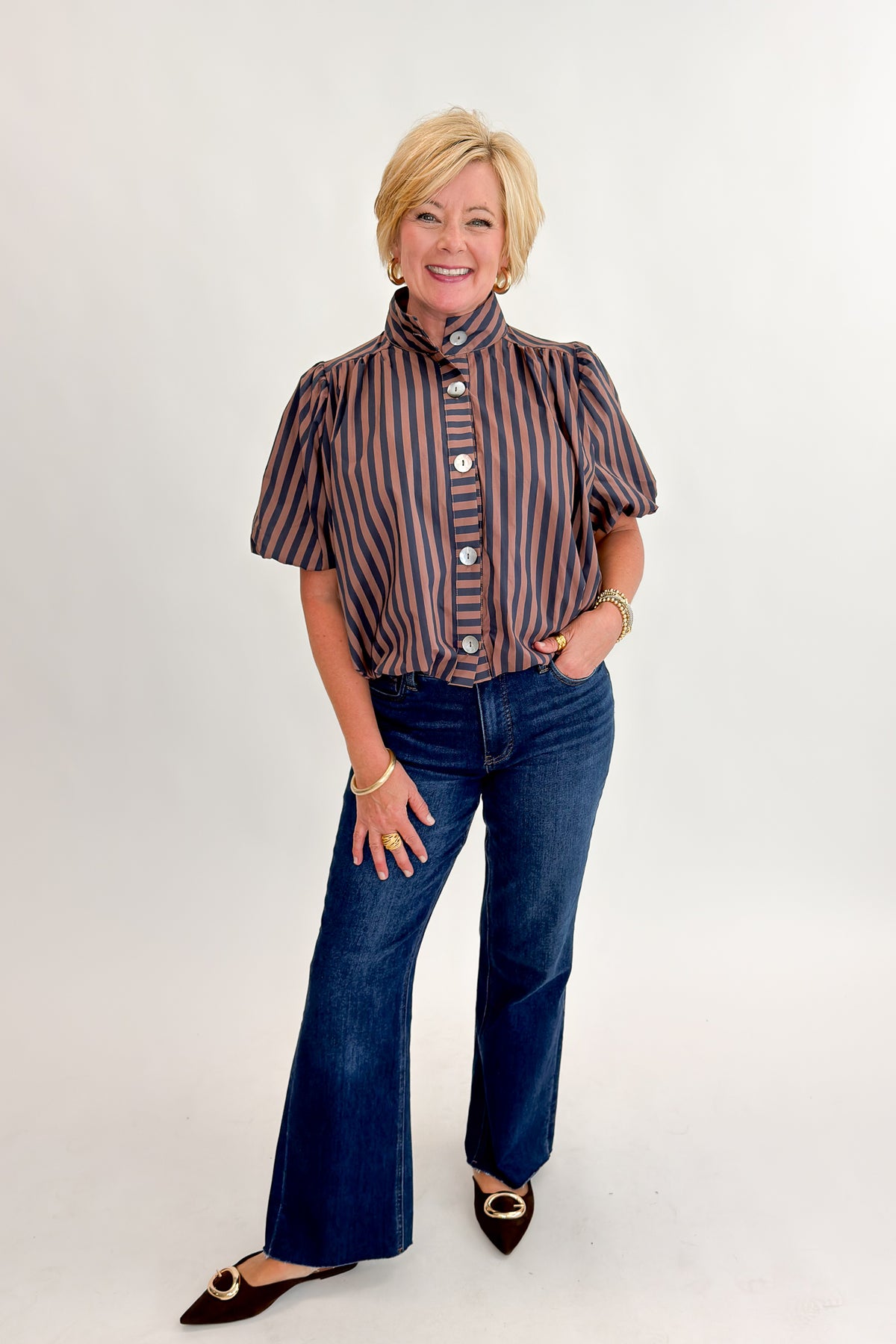 Front view of woman wearing Swagger Boutique’s Navy &amp; Brown Striped Bubble Hem Top with jeans against white studio background.