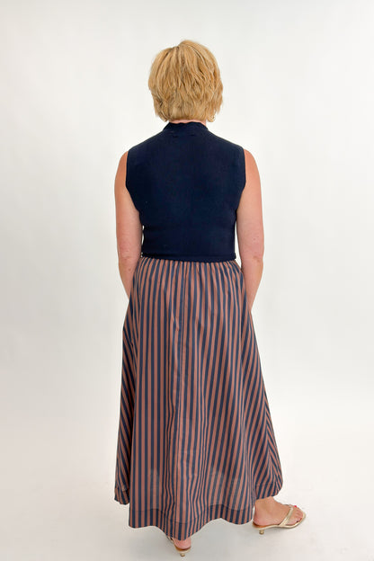 Back view of woman wearing Swagger Boutique’s Navy &amp; Brown Striped Layered Mock Neck Midi Dress against white studio background.