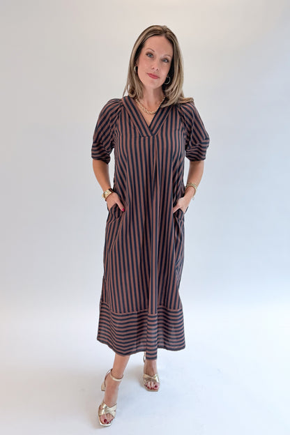 Front view of woman wearing Swagger Boutique’s Navy &amp; Brown Striped Puff Sleeve Midi Dress by Entro with heels against white studio background.