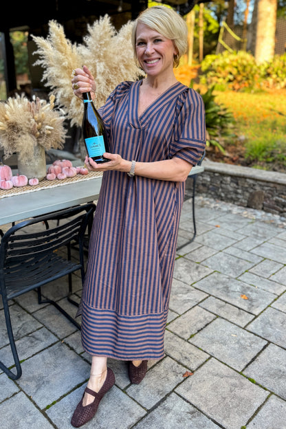 Front view of woman wearing Swagger Boutique’s Navy &amp; Brown Striped Puff Sleeve Midi Dress by Entro standing outside at a party.