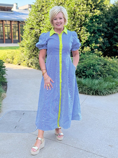 Front view of woman wearing Swagger Boutique’s Navy &amp; Citron Striped Midi Dress by Entro with sandals standing outside at a park.