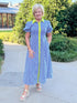 Front view of woman wearing Swagger Boutique’s Navy & Citron Striped Midi Dress by Entro with sandals standing outside at a park.
