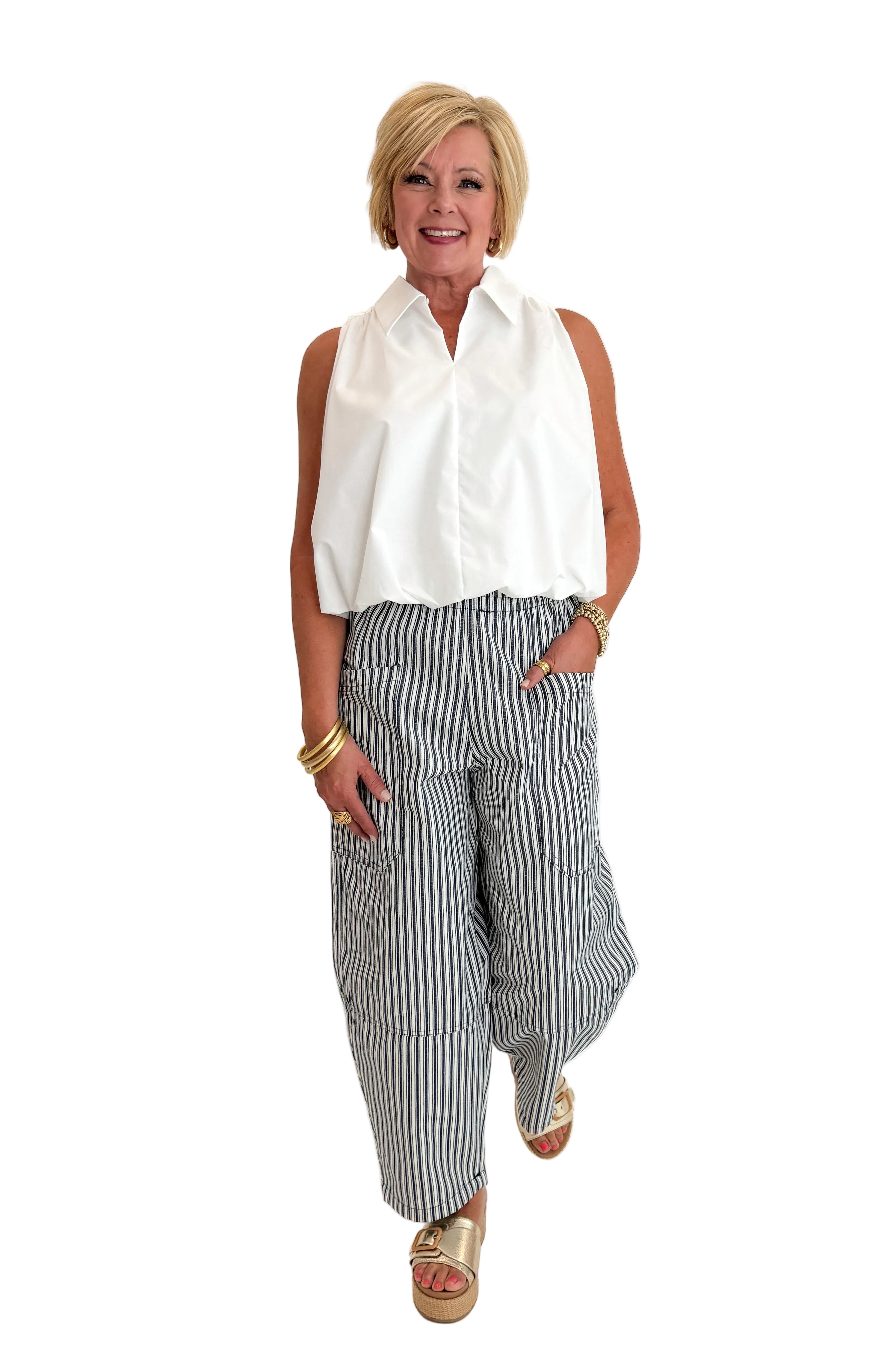 Front view of woman wearing Swagger Boutique’s In Full Swing Navy &amp; Cream Striped Barrel Pants with white top and sandals against white studio background.