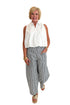 Front view of woman wearing Swagger Boutique’s In Full Swing Navy & Cream Striped Barrel Pants with white top and sandals against white studio background.