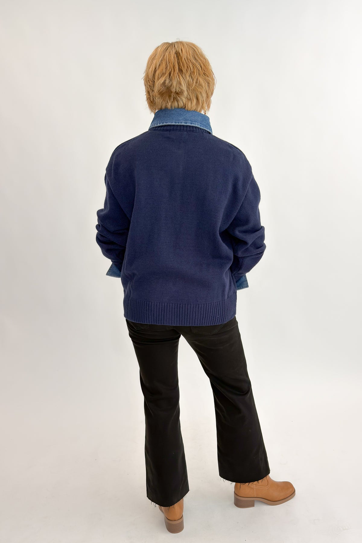 Back view of woman wearing Swagger Boutique’s Navy &amp; Denim Collared Sweater with jeans against white studio background.