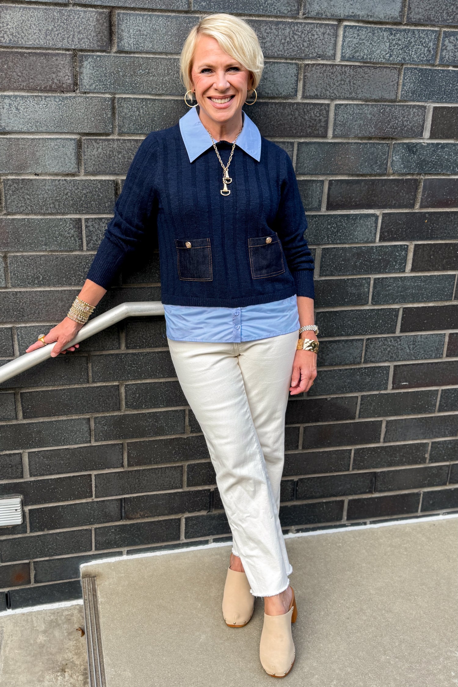 Front view of woman wearing Swagger Boutique’s Navy &amp; Denim Pocket Sweater with jeans standing against a brick wall.