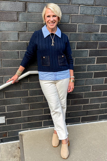 Front view of woman wearing Swagger Boutique’s Navy &amp; Denim Pocket Sweater with jeans standing against a brick wall.