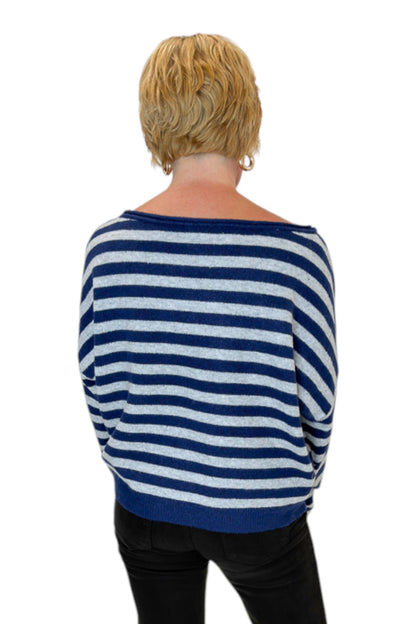 Back view of woman wearing Swagger Boutique’s Navy &amp; Grey Striped Sweater with jeans against white studio background.
