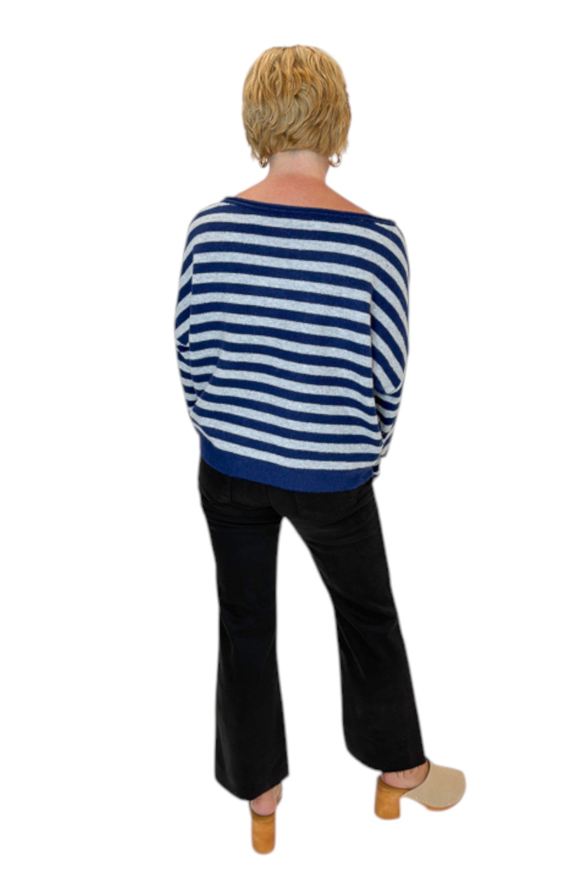 Back view of woman wearing Swagger Boutique’s Navy &amp; Grey Striped Sweater with jeans against white studio background.