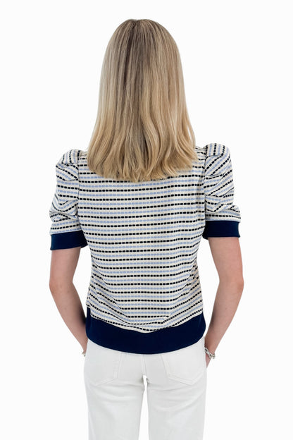 Back view of woman wearing Swagger Boutique’s Navy &amp; Light Blue Striped Short Sleeve Top by Entro with jeans against white studio background.