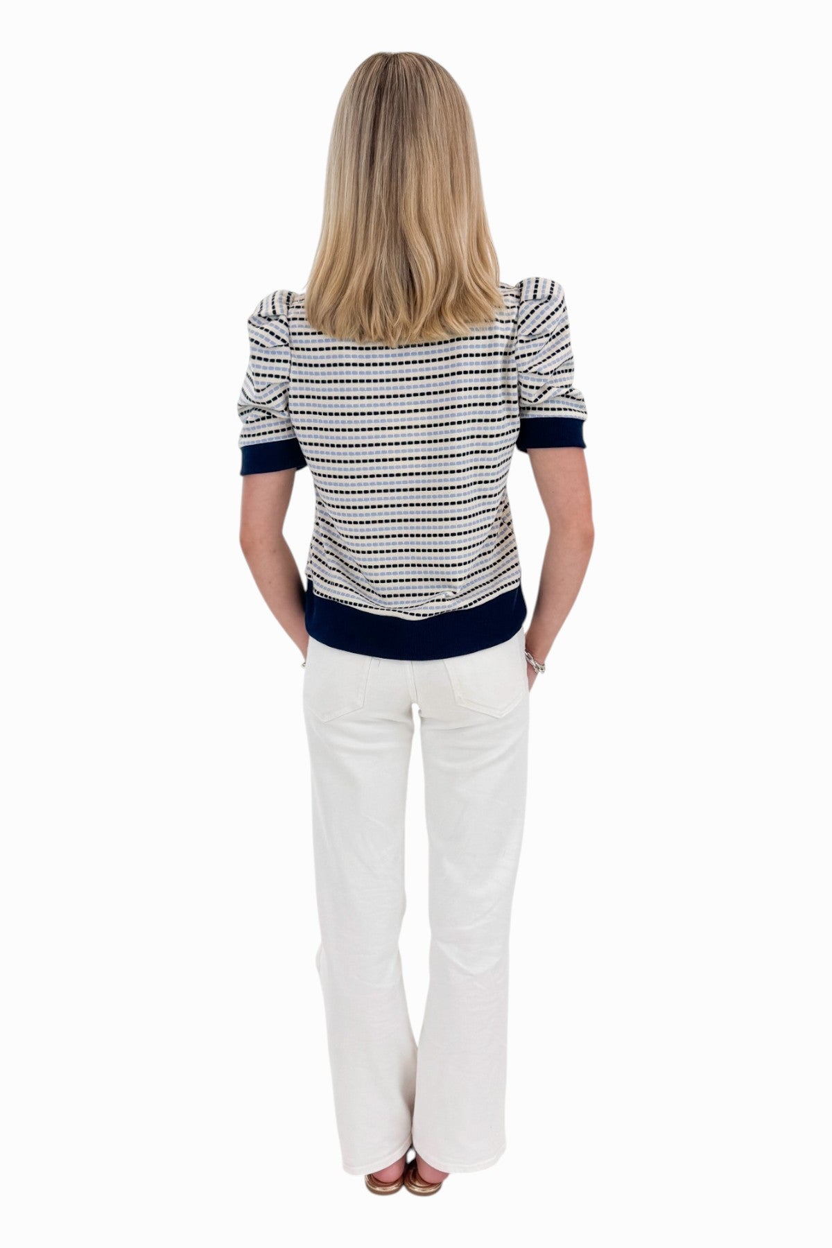 Back view of woman wearing Swagger Boutique’s Navy &amp; Light Blue Striped Short Sleeve Top by Entro with jeans against white studio background.