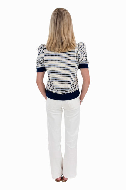 Back view of woman wearing Swagger Boutique’s Navy &amp; Light Blue Striped Short Sleeve Top by Entro with jeans against white studio background.