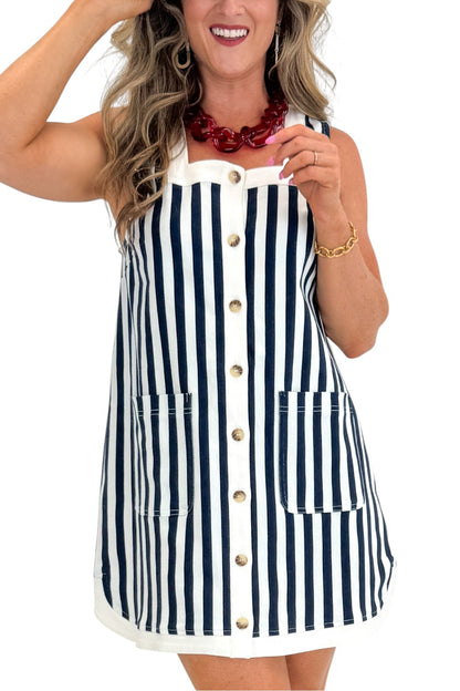 Front detail view of woman wearing Swagger Boutique’s Navy &amp; White Striped Button Up Mini Dress by Entro with sandals against white studio background.