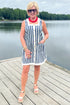 Front view of woman wearing Swagger Boutique’s Navy & White Striped Button Up Mini Dress by Entro with sandals outside at the lake.