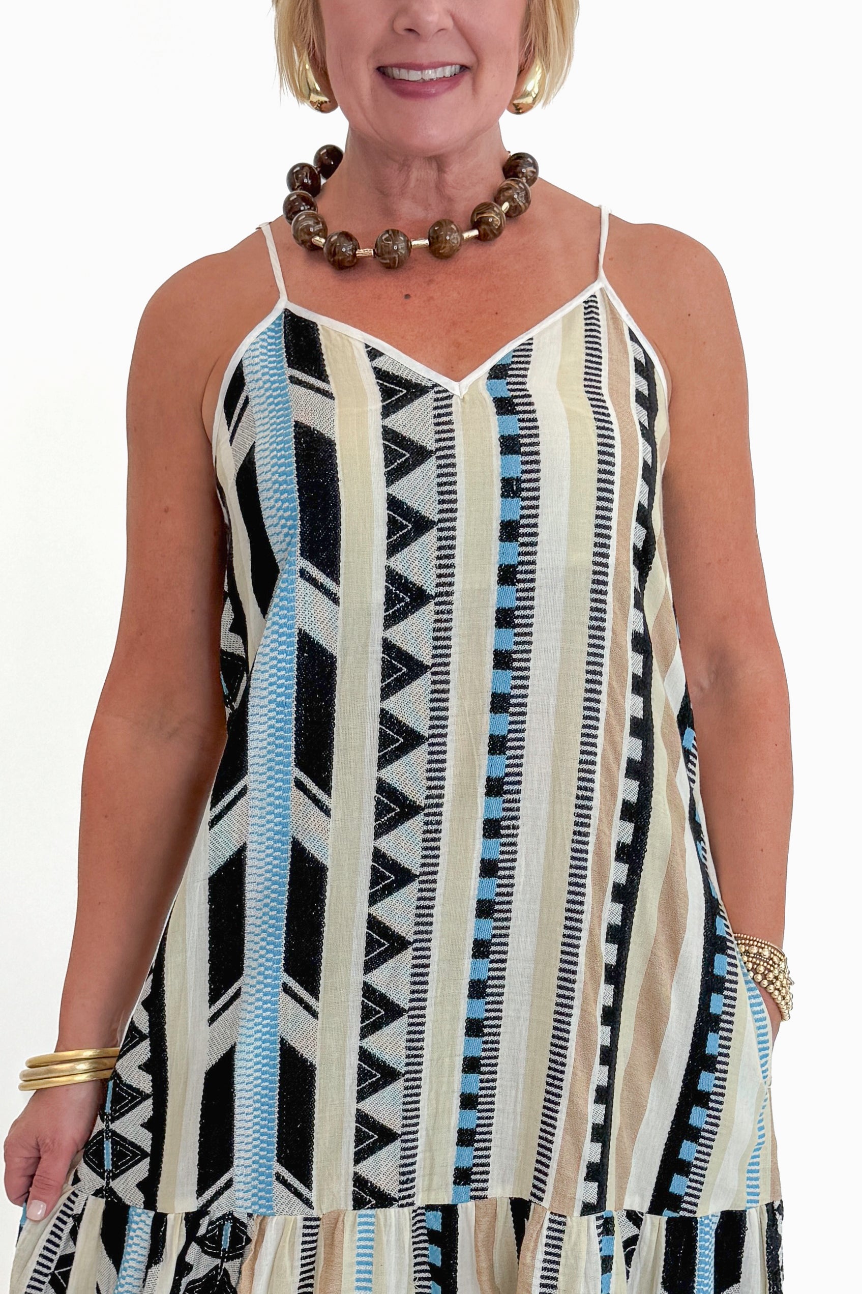 Front detail view of woman wearing Swagger Boutique’s Neutral Aztec Print Maxi Dress with sandals against white studio background.