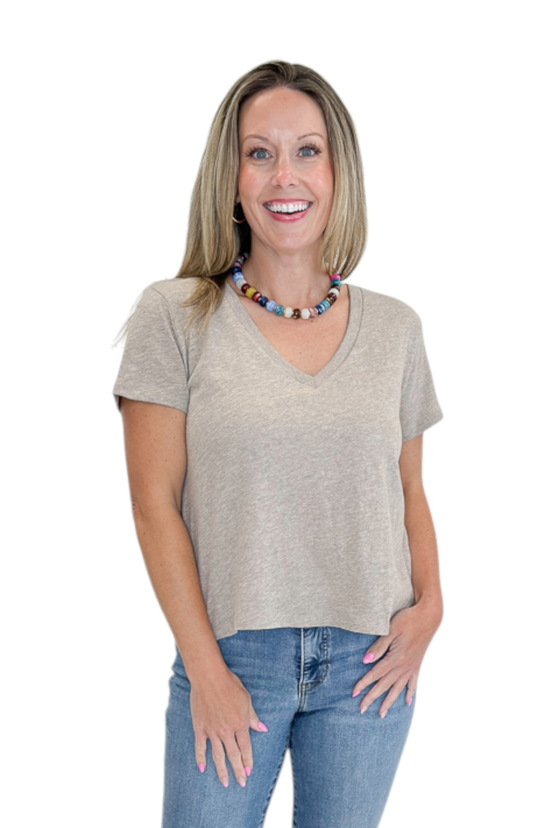 Front view of woman wearing Swagger Boutique’s Heather Ash Nomad V-Neck Tee by Z Supply with jeans against white studio background.