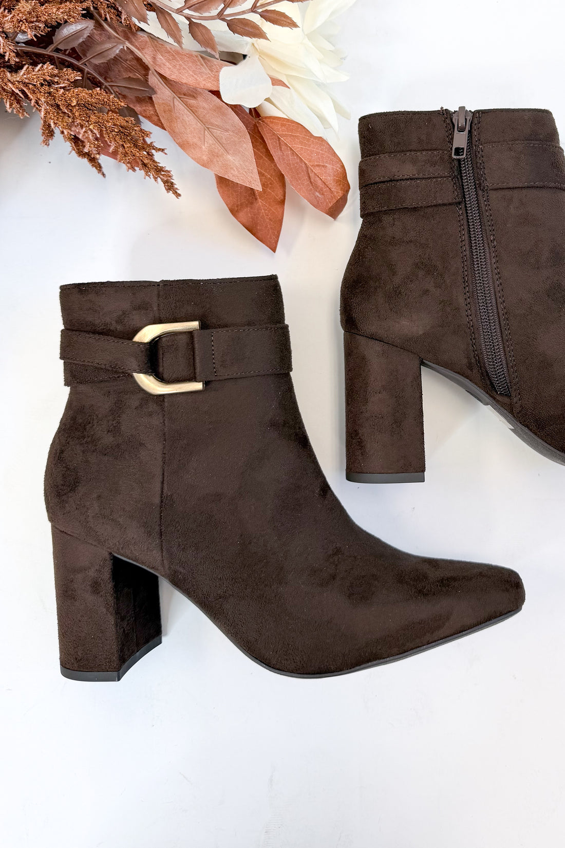 Novella- Brown Suede Buckle Booties against white studio background.