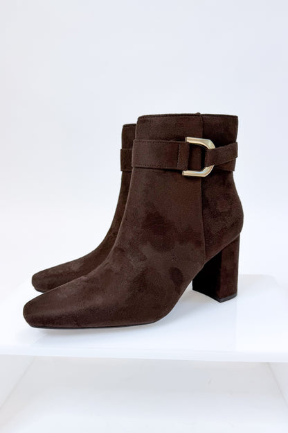 Novella- Brown Suede Buckle Booties against white studio background.